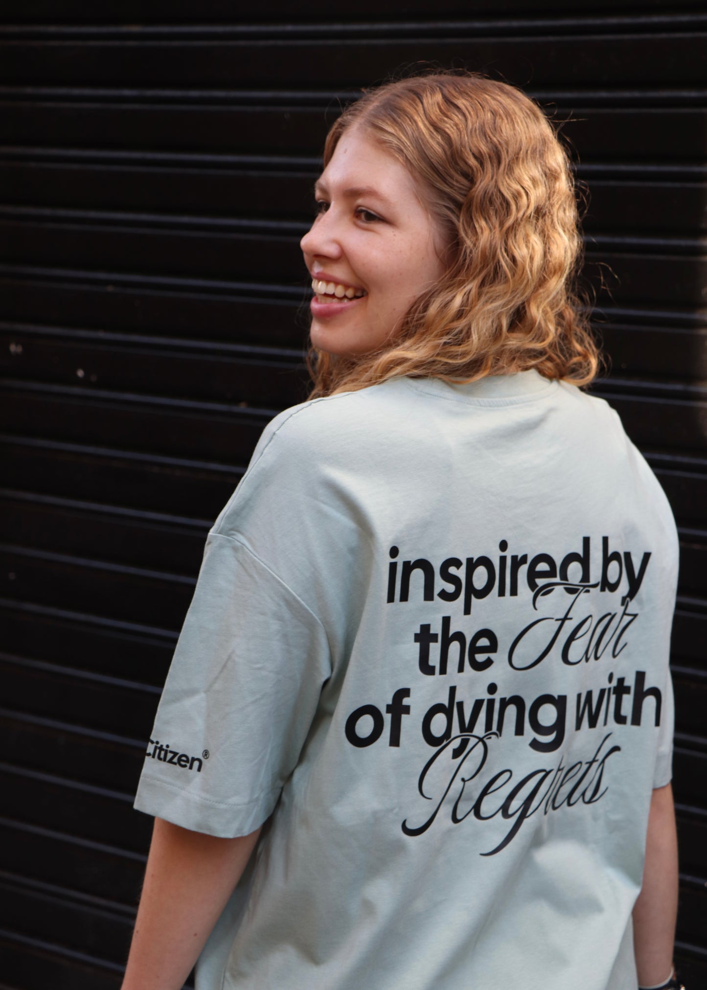 Camiseta Oversize Pistacho - Inspired By The Fear Of Dying With Regrets I New Citizen. Con lema estampado motivador, 100% algodón, corte para hombre y estilo urbano. Toma riesgos, crea tu propia historia y vive sin arrepentimientos.